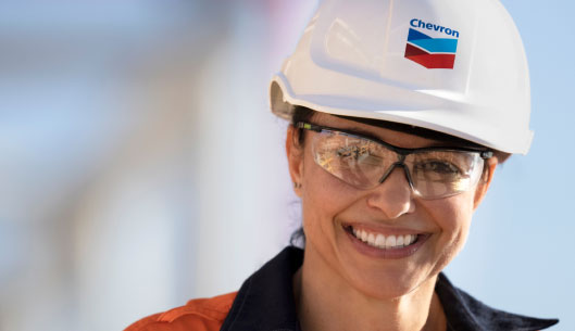 woman wearing chevron branded hard hat smiling.